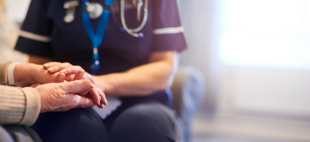A nurse holding a patient's hand